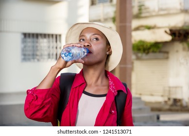 young tourist woman standing outdoors with back drinking water. - Shutterstock ID 1241513071