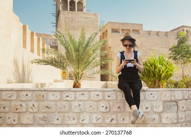 Young Tourist Woman Taking Rest During Sightseeing And Using Smart Phone