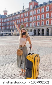 Young Tourist Woman Wearing Protective Face Mask Happy And Excited In Plaza Mayor Madrid Spain Enjoying Holidays In Europe After Coronavirus Outbreak Lockdown. In COVID-19 New Normal And Travel.