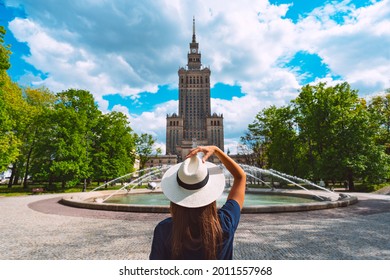 Young Tourist Woman In White Sun Hat Walking In The Park Near Palace Of Culture And Science In Warsaw City, Poland. Summer Vacation In Warsaw