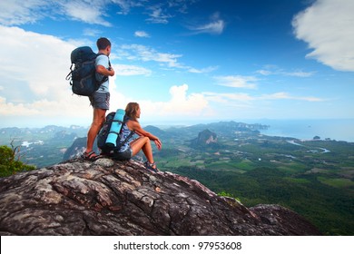 Young tourists with backpacks enjoying valley view from top of a mountain - Powered by Shutterstock