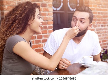 Young Tourists Eating Breakfast At Restaurant Table Outside Side