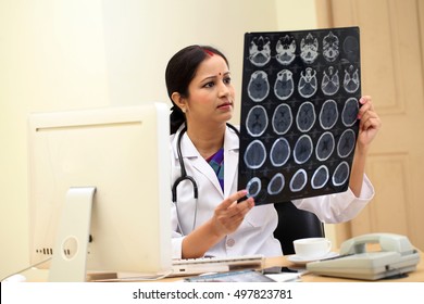 Young Traditional Female Doctor Examine Brain X-ray Picture