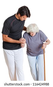 Young Trainer Assisting Senior Woman Holding Walking Stick Over White Background