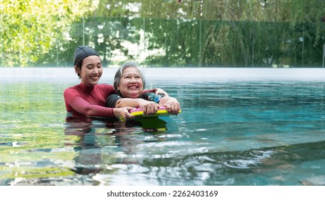 Young trainer helping senior woman in aqua aerobics and working out in the pool. old woman and mature man doing aqua aerobics exercise in swimming pool, Elderly sports, and active lifestyle concept. - Powered by Shutterstock