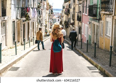 Young travel woman is walking on the beautiful old cozy street of Lisbon in Portugal