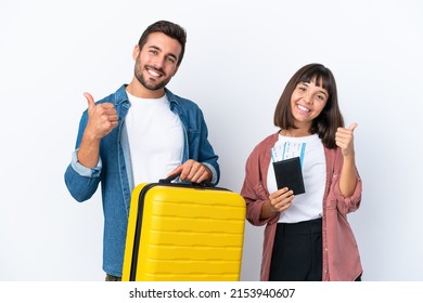 Young Traveler Couple Holding A Suitcase And Passport Isolated On White Background Giving A Thumbs Up Gesture With Both Hands And Smiling