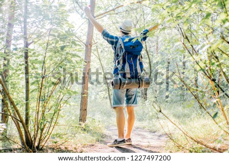 Similar – Hiker woman with backpack raising her arms into the forest