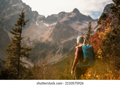  Young traveler hiking girl with backpacks. Hiking in mountains. Sunny landscape. Tourist traveler on background view mockup. High tatras , slovakia - Shutterstock ID 2110575926