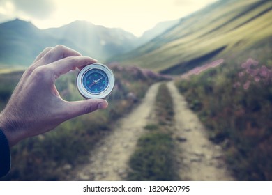 young traveler holding compass in mountain - Shutterstock ID 1820420795