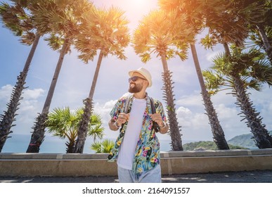 Young traveler man at summer holiday vacation with beautiful palms and seascapes at background - Powered by Shutterstock