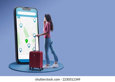 Young traveler searching for locations on a map, she is using a big smartphone, copy space - Shutterstock ID 2230311349