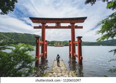 Young Traveler Takeing Photo At Red Torii Gate Of Hakone Shrine At  Lake Ashi, Japan