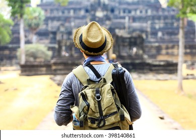 Young traveler wearing a hat with backpack and tripod - at Angkor Wat, Siem Reap, Cambodia