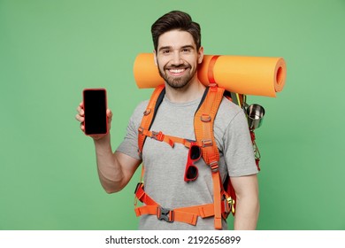 Young Traveler White Man Carry Backpack Stuff Mat Use Mobile Phone With Blank Screen Isolated On Plain Green Background Tourist Lead Active Lifestyle Walk On Spare Time Hiking Trek Travel Trip Concept