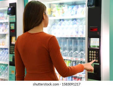 Young traveler woman choosing a snack or drink at vending machine in airport. Vending machine with girl. - Shutterstock ID 1583091217
