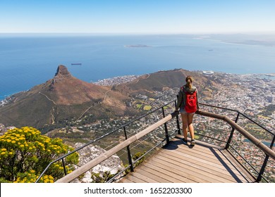 Young Traveller Woman Enjoying View Of Lions Head, South Afrika From Table Mountain. Fantastic Landscape Of City And Blue Endless Ocean From High Lookout Platform. Summer Vacation Travelling Concept.