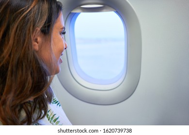 Young Traveller Woman Sitting Inside Plane At The Airport With Sky View From The Window