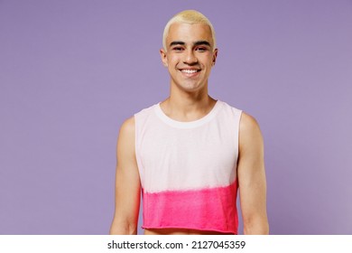 Young Trendy Blond Hispanic Latin Gay Man 20s With Make Up In Fashionable Bright Pink Top Look Camera Isolated On Plain Pastel Purple Background Studio Portrait. People Lifestyle Fashion Lgbtq Concept