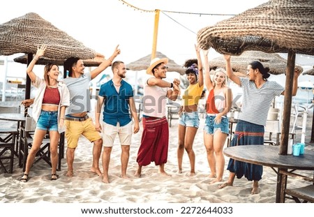 Young trendy friends dancing and having fun at chiringuito beach club - Friendship life style concept with happy people together at spring break festival on summer vacation - Warm bright filter