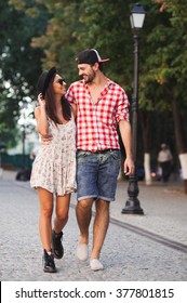 Young And Trendy Man And Woman Models Walks On The Street. In Old Town. Fashion Style