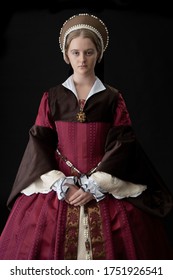 A Young Tudor Woman In A Red And Brown Dress And A French Hood