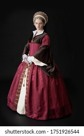 A Young Tudor Woman In A Red And Brown Dress And A French Hood