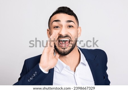 Young turkish handsome guy wearing ellegant smart suit screaming at camera standing over grey background in studio isolated. Stock photo © 