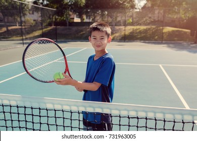 Young Tween Asian Boy Tennis Beginner Player On Outdoor Blue Court