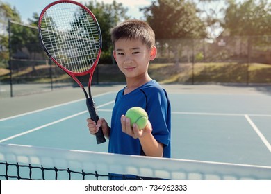 Young Tween Asian Boy Tennis Player On Outdoor Blue Court