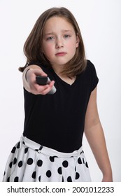 A Young Tween Girl Frustrated With A Remote Control Pointing At The Camera.