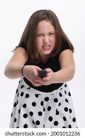 A Young Tween Girl Frustrated With A Remote Control Pointing At The Camera.