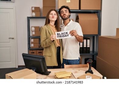 Young Two People Holding Black Friday Banner At Small Business Store Looking At The Camera Blowing A Kiss Being Lovely And Sexy. Love Expression. 