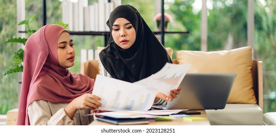 Young two smiling happy beautiful asian muslim woman relaxing using laptop computer working and video conference meeting at home.work from home concept
