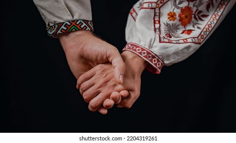 Young Ukrainian Couple In Embroidered National Shirts Holding Hands. Man And Woman On Black Background. Lovers, Family, Trust, Love And Happiness Concept. High Quality 