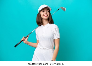 Young Ukrainian golfer player woman isolated on blue background looking to the side and smiling