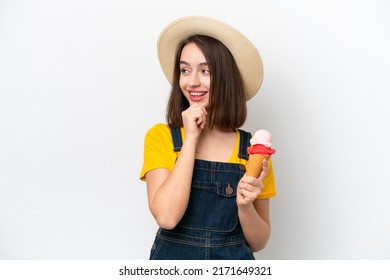 Young Ukrainian woman with a cornet ice cream isolated on white background thinking an idea and looking side