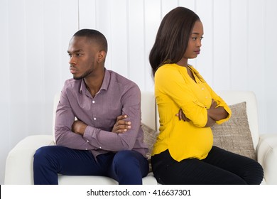 Young Unhappy African Couple Sitting Back To Back On Sofa At Home