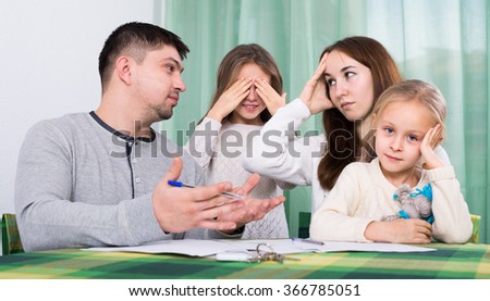 Young unhappy parents having quarrel adout documents in front of children indoor Stock photo © 