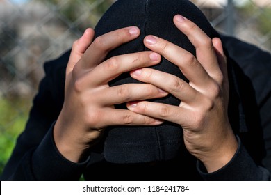 Young Unidentifiable Teenage Boy  Holding Hes Head At The Correctional Institute , Conceptual Image Of Juvenile Delinquency, Focus On The Boys Hand.