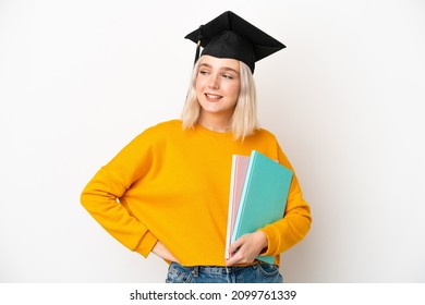 Young university caucasian woman graduate isolated on white background posing with arms at hip and smiling