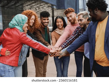 Young university students stacking hands together outdoor - Multiracial people and community concept - Powered by Shutterstock