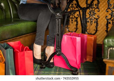 Young Unrecognizable Woman Has Shopping Bags Under The Table