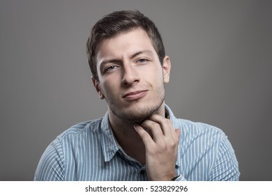 Young Unshaven Man Scratching Itchy Beard With Painful Expression Looking At Camera