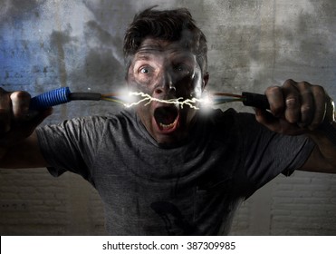 Young Untrained Man Joining Electrical Cable Suffering Domestic Accident With Dirty Burnt Face In Funny Shock Expression Screaming Crazy In Electricity DIY Repairs Danger Concept