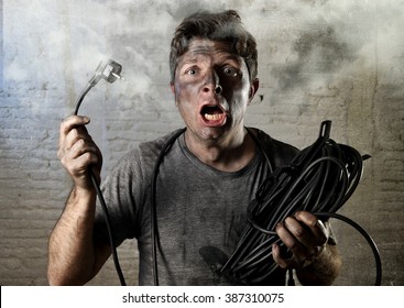 Young Untrained Man Joining Electrical Cable Suffering Domestic Accident With Dirty Burnt Face In Funny Shock Expression Screaming Crazy In Electricity DIY Repairs Danger Concept