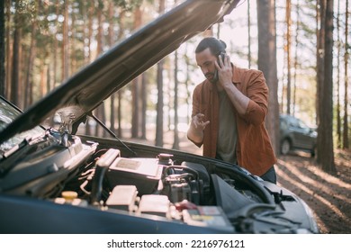 A Young Upset Man Calls By Phone To A Car Service Near A Broken Car Far Outside The City. The Car Broke Down On A Trip. Calling A Tow Truck.