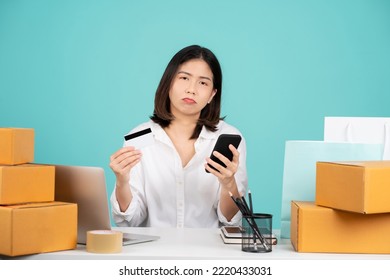 Young Upset Sad In Shirt Sit Work At White Office Desk With Pc Laptop Using Mobile Cell Phone Hold Credit Bank Card Do Online Shopping Order Isolated On Bright Green Background Studio