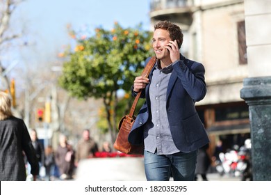 Young urban businessman on smart phone running in street talking on smartphone smiling wearing jacket and leather laptop bag on Passeig de Gracia, Barcelona, Catalonia, Spain. - Powered by Shutterstock