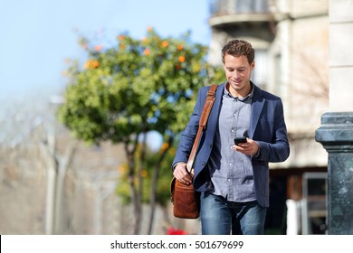 Junge urbane Geschäftsleute, die mit Smartphone-Apps auf der Straße gehen und SMS-Nachrichten auf Smartphone mit smarter Jacke schicken. Stadtluft-Pendelverkehr für Fußgänger.